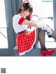 A woman in a red and white uniform sitting on a window sill.