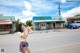 A woman walking down the street holding a cup of coffee.