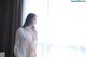 A naked woman standing in front of a window.