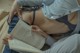 A woman is reading a book on a bed.