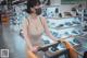 A woman wearing a face mask pushing a shopping cart in a store.