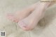 A close up of a woman's bare feet on a bed.