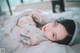 A woman laying on top of a bed covered in plastic.